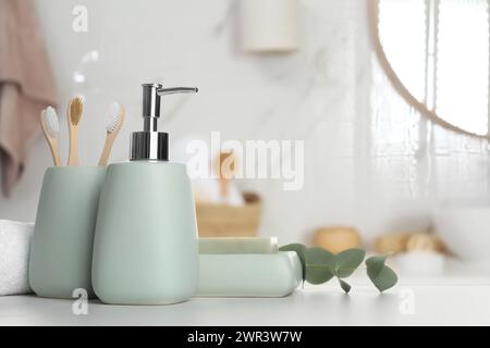 Accessoires de bain. Différents produits de soins personnels et feuilles d'eucalyptus sur table blanche dans la salle de bain Banque D'Images