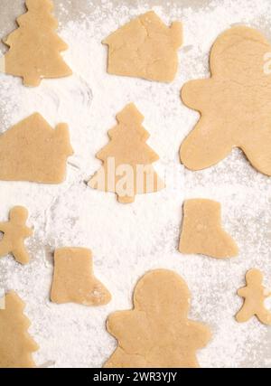 Biscuits de Noël crus dans différentes formes sur papier parchemin, plat Banque D'Images