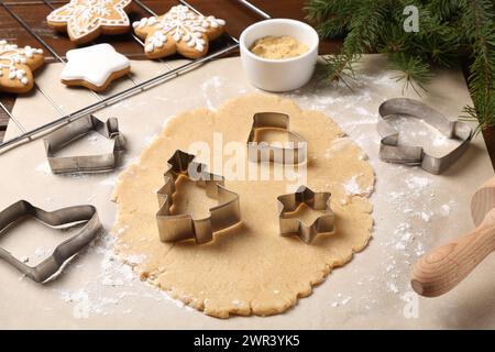 Faire des biscuits de Noël. Pâte crue et différents couteaux en métal sur la table Banque D'Images