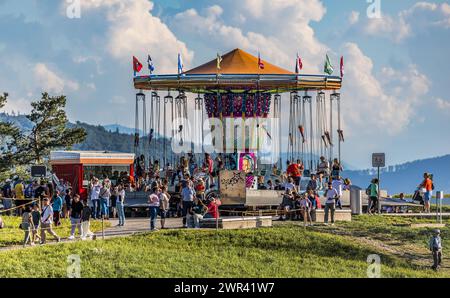 Ein Karussell im Flughafenpark oberhalb des Circle. Die Festbesucher vergnügen sich am Flughafenfest zum 75. Geburtstag des Flughafen Zürich. (Zürich, Banque D'Images