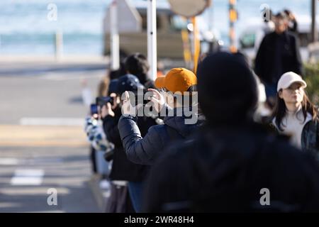 Les touristes prennent des photos autour du passage à niveau de la gare Kamakura Kokomae d'Enoden dans la ville de Fujisawa, préfecture de Kanagawa, le 28 février 2024. Ce passage à niveau est présenté dans la célèbre série d'animation japonaise 'Slam Dunk'. C'est une destination touristique populaire pour les touristes nationaux et étrangers à visiter et à prendre des photos. Cependant, en raison du grand nombre de touristes visitant le train d'Enoden est devenu extrêmement fréquenté, et les résidents vivant le long de la ligne ont été touchés par le problème du surtourisme. Crédit : Yosuke Tanaka/AFLO/Alamy Live News Banque D'Images