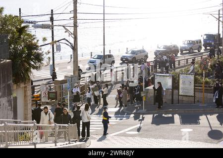 Les touristes prennent des photos autour du passage à niveau de la gare Kamakura Kokomae d'Enoden dans la ville de Fujisawa, préfecture de Kanagawa, le 28 février 2024. Ce passage à niveau est présenté dans la célèbre série d'animation japonaise 'Slam Dunk'. C'est une destination touristique populaire pour les touristes nationaux et étrangers à visiter et à prendre des photos. Cependant, en raison du grand nombre de touristes visitant le train d'Enoden est devenu extrêmement fréquenté, et les résidents vivant le long de la ligne ont été touchés par le problème du surtourisme. Crédit : Yosuke Tanaka/AFLO/Alamy Live News Banque D'Images