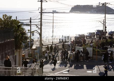 Les touristes prennent des photos autour du passage à niveau de la gare Kamakura Kokomae d'Enoden dans la ville de Fujisawa, préfecture de Kanagawa, le 28 février 2024. Ce passage à niveau est présenté dans la célèbre série d'animation japonaise 'Slam Dunk'. C'est une destination touristique populaire pour les touristes nationaux et étrangers à visiter et à prendre des photos. Cependant, en raison du grand nombre de touristes visitant le train d'Enoden est devenu extrêmement fréquenté, et les résidents vivant le long de la ligne ont été touchés par le problème du surtourisme. Crédit : Yosuke Tanaka/AFLO/Alamy Live News Banque D'Images