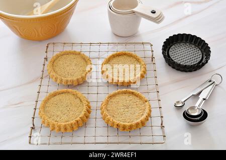 Gâteaux sains aux amandes et au lin cuits sur des coquilles de tarte cannelées avec des ustensiles de cuisson au format horizontal. Une alternative saine à la cuisson à la farine blanche Banque D'Images