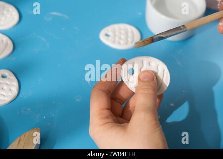 Créateur utilise de l'argile sèche blanche à l'air pour faire le décor aux vacances de PÂQUES. Créer une activité de loisirs qui implique les doigts. Bricolage artisanat d'art moderne Banque D'Images