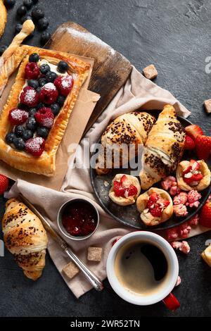 Différentes pâtisseries savoureuses fraîchement cuites sur fond sombre. Vue de dessus. Banque D'Images