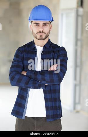 photo d'un jeune homme optimiste joyeux constructeur en casque Banque D'Images