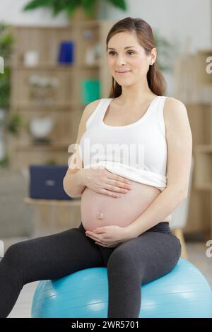 une jeune femme enceinte s'est mise en forme sur le fitball Banque D'Images