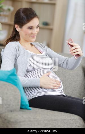 femme enceinte prenant le selfie sur un smartphone Banque D'Images