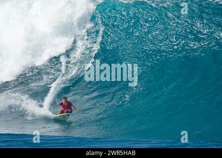 Un jeune homme fait du surf sur une grosse vague à Pipeline, rive nord, Hawaï. Banque D'Images