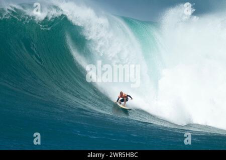 Kelly Slater surfe sur une énorme vague lors du concours de surf sur grande vague Eddie Aikau à Waimea Bay. Banque D'Images