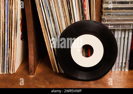 Disques vinyle empilés avec cassettes sur les meubles. Banque D'Images