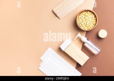 Vue de dessus des outils d'épilation sur fond beige. Équipement d'épilation professionnel pour une peau soyeuse et sans poils, concept de toilettage et de spa. Banque D'Images