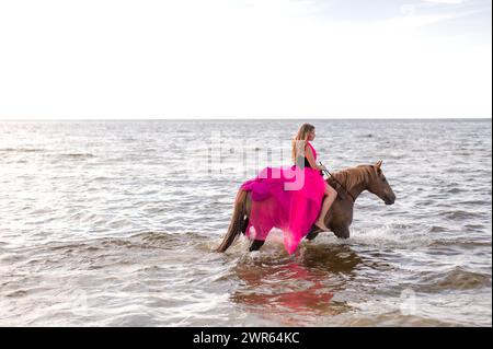 Femme en cheval d'équitation cap rose Banque D'Images
