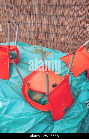 Chaises rouges obsolètes abandonnées dans la cour arrière, focus sélectif Banque D'Images