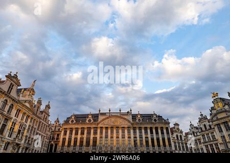 Bruxelles, Belgique, le 23 juin 2023, Un ensemble pittoresque de guildhalls de la Grand-place sous un ciel captivant, où les façades complexes sont embrassées par la douce lueur de la lumière du soleil qui s'estompe. Des nuages ornent le ciel au-dessus des Guildhalls historiques de la Grand-place. Photo de haute qualité Banque D'Images