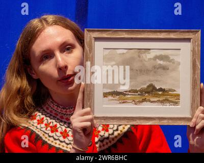 Londres, Angleterre, Royaume-Uni. 11 mars 2024. Membre du personnel pose à l'aquarelle, représentant un paysage nuageux, signé par l'artiste Dame Judi Dench. (Crédit image : © Tayfun Salci/ZUMA Press Wire) USAGE ÉDITORIAL SEULEMENT! Non destiné à UN USAGE commercial ! Crédit : ZUMA Press, Inc/Alamy Live News Banque D'Images