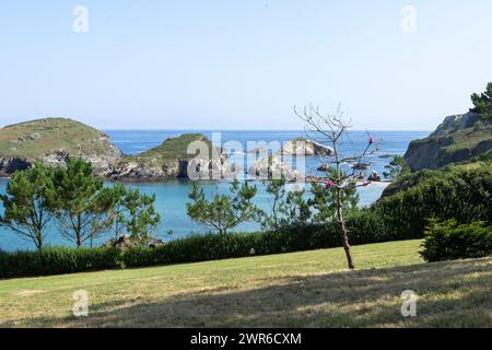 beau paysage côtier avec de la verdure, des formations rocheuses et une mer bleue claire sous un ciel lumineux Banque D'Images