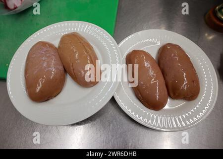 Tanne, Allemagne. 11 mars 2024. Les testicules de taureau reposent dans un bol en préparation d'un plat au restaurant Brockenbauer à Tanne. La nouvelle délicatesse sera bientôt ajoutée au menu du restaurant. Brockenbauer Thielecke à Tanne commercialise près de 100 % de ses bovins. Ils ont créé une spécialité inhabituelle sous la forme de testicules de taureau, qui doivent être servis comme huîtres de montagne. Crédit : Matthias Bein/dpa/Alamy Live News Banque D'Images