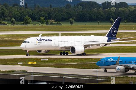 Ein Airbus A350-900 von Lufthansa Rollt zur Startbahn des Flughafen München. Kennung : d-AIXI. Die Boeing 737-800 von KLM Royal Dutch Airlines mousses la guerre Banque D'Images