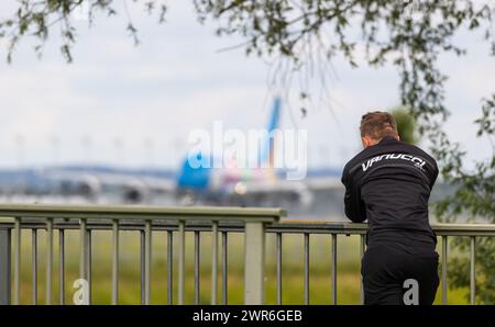 Eine männliche person schaut wie ein Airbus A380-800 von der Südbahn des Flughafen München startet. (München, Allemagne, 28.05.2022) Banque D'Images