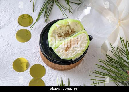 Dessert mochi. Gâteau vert avec garniture à la crème. Poire et fromage. Pièce en coupe transversale. Couper. Banque D'Images