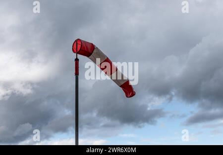 Ein Windsack weht vor dunklen Wolken BEI Rottweil im Wind. Rottweil Baden-Württemberg Deutschland *** Une chaussette souffle dans le vent devant des nuages sombres près de Rottweil Rottweil Baden Württemberg Allemagne Banque D'Images