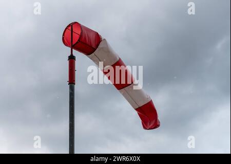 Ein Windsack weht vor dunklen Wolken BEI Rottweil im Wind. Rottweil Baden-Württemberg Deutschland *** Une chaussette souffle dans le vent devant des nuages sombres près de Rottweil Rottweil Baden Württemberg Allemagne Banque D'Images