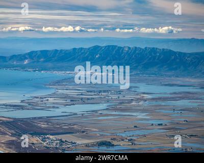 Vue aérienne des zones humides de L'Encanyissada et de la Tancada, dans le delta de l'Èbre. En arrière-plan, la chaîne de montagnes Montsià. Tarragone Catalogne Espagne Banque D'Images