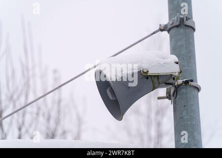 Gros plan du haut-parleur d'annonce couvert de neige à la gare Banque D'Images