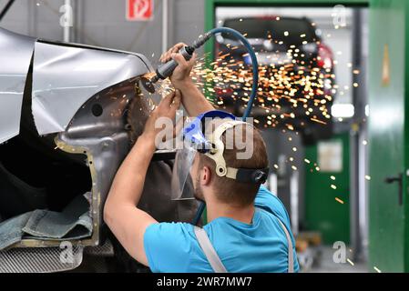 Voiture de réparation par un corps mécanique dans l'atelier Banque D'Images