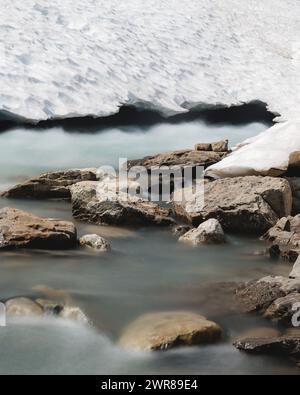 Une capture de l'eau courante venant du dessous d'un glacier par une chaude journée d'été alors que le glacier fond lentement. Banque D'Images