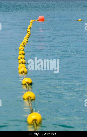 Une ligne de bouées flottant près d'une seule bouée dans l'eau Banque D'Images