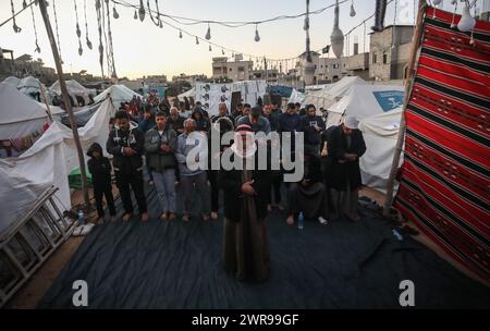 Rafah, Gaza. 11 mars 2024. Les Palestiniens déplacés prient au milieu de tentes de fortune dans le camp de réfugiés de Rafah, le premier jour du Ramadan du mois sacré des musulmans à Rafah, Gaza, le jour de Moday le 11 mars 2024. Photo de Ismael Mohamad/UPI crédit : UPI/Alamy Live News Banque D'Images