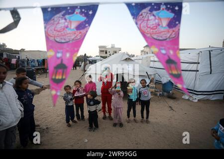 Rafah, Gaza. 11 mars 2024. Des enfants palestiniens déplacés portent des lanternes traditionnelles « fanous » au milieu de tentations de fortune pendant les célébrations du début du mois de jeûne sacré musulman du Ramadan à Rafah, en Ontario, dans le sud de la bande de Gaza, le lundi 11 mars 2024. Photo de Ismael Mohamad/UPI. Crédit : UPI/Alamy Live News Banque D'Images