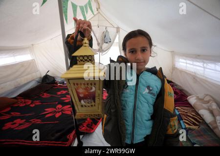 Rafah, Gaza. 11 mars 2024. Un enfant palestinien déplacé porte des lanternes traditionnelles « fanous » au milieu de tentations de fortune pendant les célébrations du début du mois de jeûne sacré musulman du Ramadan à Rafah, en Ontario, dans le sud de la bande de Gaza, lundi 11 mars 2024. Photo de Ismael Mohamad/UPI. Crédit : UPI/Alamy Live News Banque D'Images