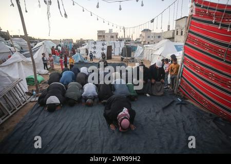 Rafah, Gaza. 11 mars 2024. Les Palestiniens déplacés prient au milieu de tentes de fortune dans le camp de réfugiés de Rafah, le premier jour du Ramadan du mois sacré des musulmans à Rafah, Gaza, le jour de Moday le 11 mars 2024. Photo de Ismael Mohamad/UPI crédit : UPI/Alamy Live News Banque D'Images