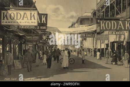 Le Bureau commercial oriental, le Bureau commercial oriental (Port Said), Prins Farouk Street à Port Saïd, Egypte, avec de la publicité pour Kodak à gauche et à droite., anonyme, Port Saïd, c. 1930, papier, hauteur 83 mm × largeur 134 mm, hauteur 90 mm × largeur 141 mm, photographie Banque D'Images