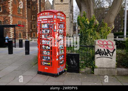 Une boîte téléphonique K6 hors service recouverte d'autocollants et de graffitis, Lambeth Palace Road, Londres, Royaume-Uni. 9 mars 2024 Banque D'Images