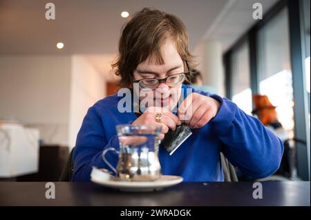 41 ans femme avec le syndrome de Down apprenant à infuser du thé, Tienen, Belgique. Autorisation du modèle Banque D'Images