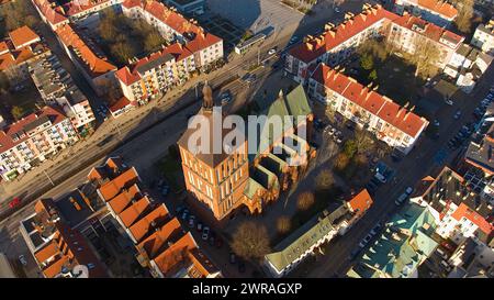 Un drone capture le centre-ville de Koszalin baigné de lumière dorée, avec la cathédrale, Victory Street et l'hôtel de ville. Banque D'Images