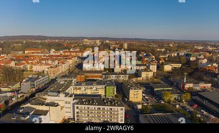 Un drone capture le centre-ville de Koszalin baigné de lumière dorée, avec la cathédrale, Victory Street et l'hôtel de ville. Banque D'Images