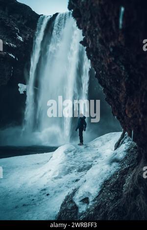 Femme photographe en hiver en Islande visitant la cascade de Skogafoss Banque D'Images