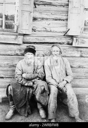 Deux hommes assis, à l'extérieur de la maison en rondins, pleine longueur, Russie, M. Dmitriev'., 1895?, hommes, vêtements et robes, Russie, 1890-1900, tirages photographiques, 1890-1900., Portrait Photographs, 1890-1900, tirages photographiques, 1890-1900, 1 tirage photographique Banque D'Images