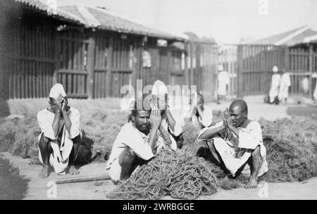 Prisonniers de Rangoon, photographie montre cinq prisonniers masculins accroupis avec les mains pressées ensemble au milieu d'un matériau fibreux à Rangoon, Birmanie., Carpenter, Frank G. (Frank George), 1855-1924, photographe, entre 1910 et 1920, Carpenter, Frank G., (Frank George), 1855-1924, voyages, Europe, tirages photographiques, 1910-1920., tirages photographiques, 1910-1920, 1 tirage photographique Banque D'Images