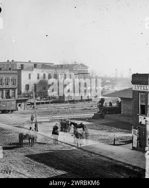 Atlanta, Ga Les civils se sont entassés sur les wagon au dépôt de chemin de fer alors que les soldats se rassemblent autour d'un spectateur stéréoscopique de S.D. Goodale & sons à côté du bureau du journal Daily Intelligencer, photographie de la guerre en Occident. Ces photographies sont de Sherman à Atlanta, septembre-novembre 1864. Après trois mois et demi de manœuvres incessantes et de combats acharnés, Sherman force Hood à abandonner le centre de munitions de la Confédération. Sherman y resta, reposant ses hommes portés par la guerre et accumulant des provisions, pendant près de deux mois et demi. Pendant l'occupation Banque D'Images