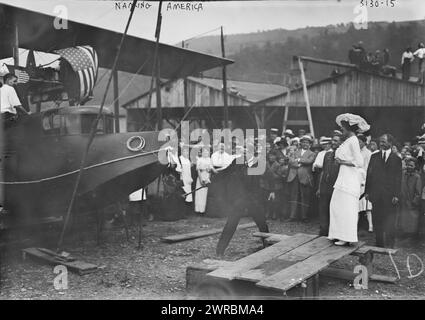 Baptisée « America », la photographie montre le baptême et le lancement de l'avion Curtiss Model H Flying Boat « America » le 22 juin 1914 à Hammondsport, New York. L'aviateur John Cyril porte utilise un marteau de forge pour briser la bouteille de champagne alors que Katherine Masson et le constructeur Glenn Curtiss (debout derrière Masson) regardent., 1914 juin 22, négatifs en verre, 1 négatif : verre Banque D'Images