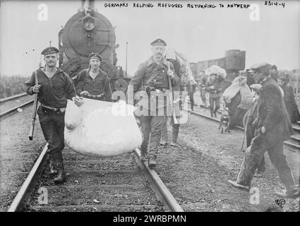 Les Allemands aident les réfugiés retournant à Anvers, photographie montrant des soldats allemands sur les voies ferrées transportant un paquet pour les réfugiés belges à Anvers, Belgique pendant la première Guerre mondiale, 1914, Guerre mondiale, 1914-1918, négatifs en verre, 1 négatif : verre Banque D'Images