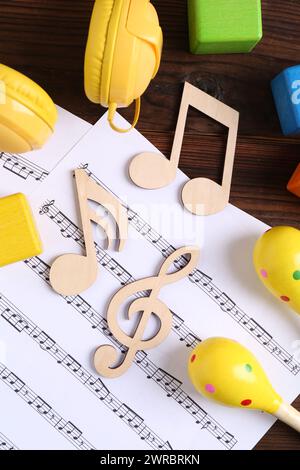 Concept de chanson de bébé. Notes en bois, feuille de musique et jouets sur table, pose à plat Banque D'Images