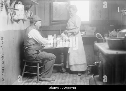 À Broad Channel - dîner, la photographie montre une femme versant un verre pour un homme assis à une table dans une maison à Broad Channel, Queens, New York City., entre CA. 1910 et env. 1915, négatifs en verre, 1 négatif : verre Banque D'Images